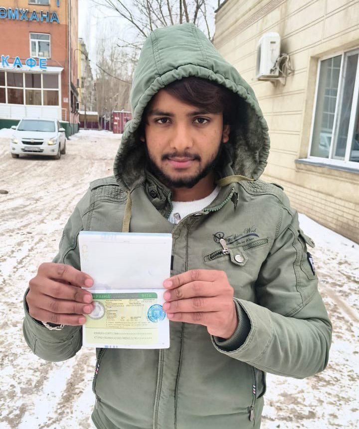 Громадянин країни Азії тримає паспорт із вклеєною робочою візою в Україну, оформленою через GoWork